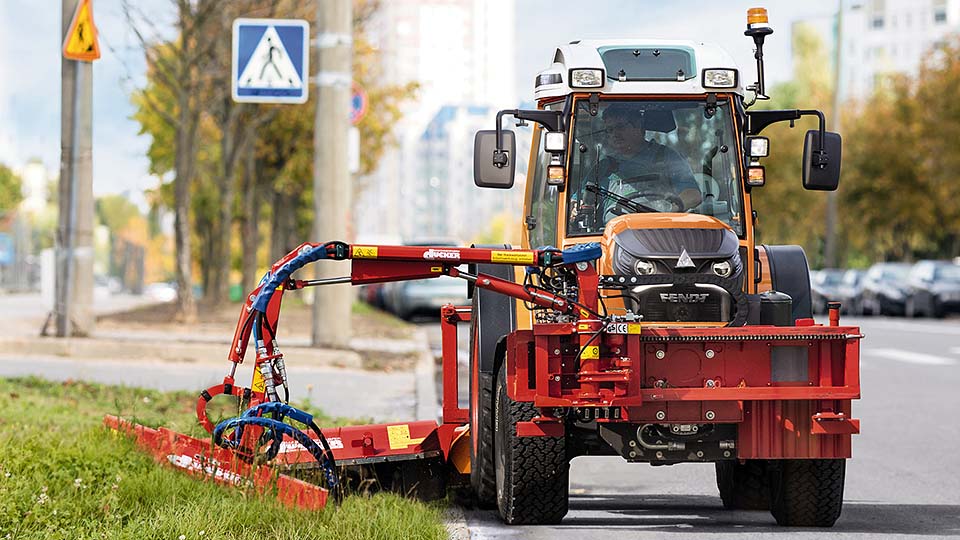 Traktor mäht den Rasen am Strassenrand